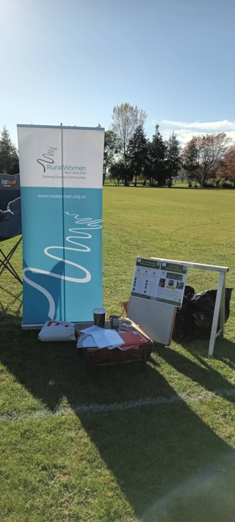 A display table at the Golden Bay Resilience Expo showing suggestion cards and dot sticker voting sheets for community resilience ideas.